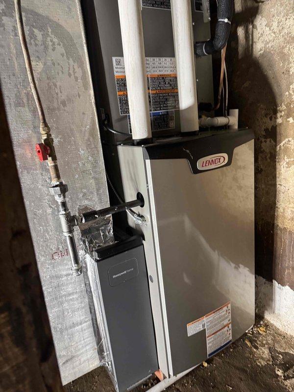 Completed full HVAC system installation at residential property, including outdoor condenser unit and indoor Lennox air handler/furnace system. Exterior condenser was positioned on concrete pad adjacent to home with proper electrical disconnect and conduit installation, while the indoor Lennox equipment was installed in basement mechanical area with copper refrigerant lines, insulated tubing, and all necessary connections properly secured to concrete block walls. System was fully installed with refrigerant piping, shut-off valves, and all manufacturer specifications verified for operational readiness.