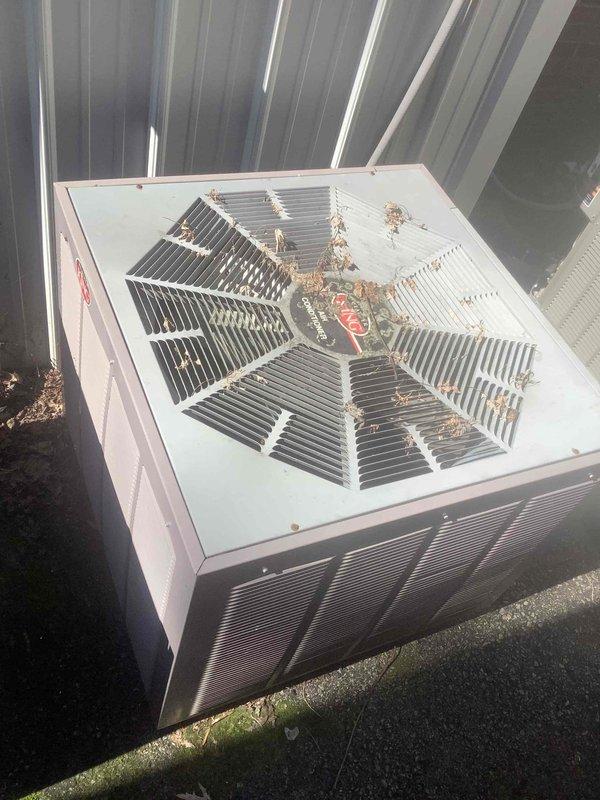 Responded to no cooling complaint in fellowship area. Inspected multiple King brand outdoor condenser units located along building exterior. Found accumulated leaves and debris on condenser fan grilles restricting airflow. Cleaned debris from affected unit, verified proper fan operation, and confirmed system returned to normal cooling operation.