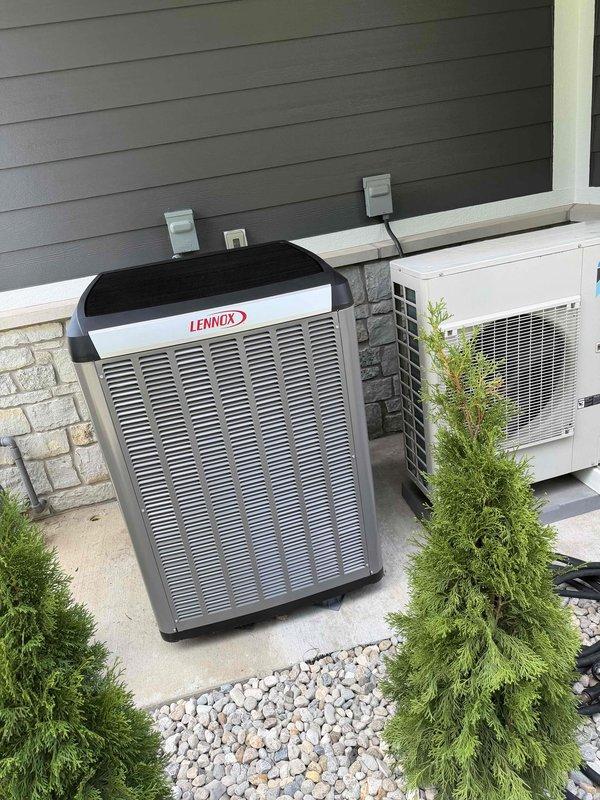 Completed full HVAC system installation including Lennox heat pump and gas furnace with outdoor condenser units mounted on concrete pads. Installed and wired thermostat control unit, established electrical disconnects, and completed all line set connections. Performed final system testing and landscaping restoration with decorative rock placement around equipment.