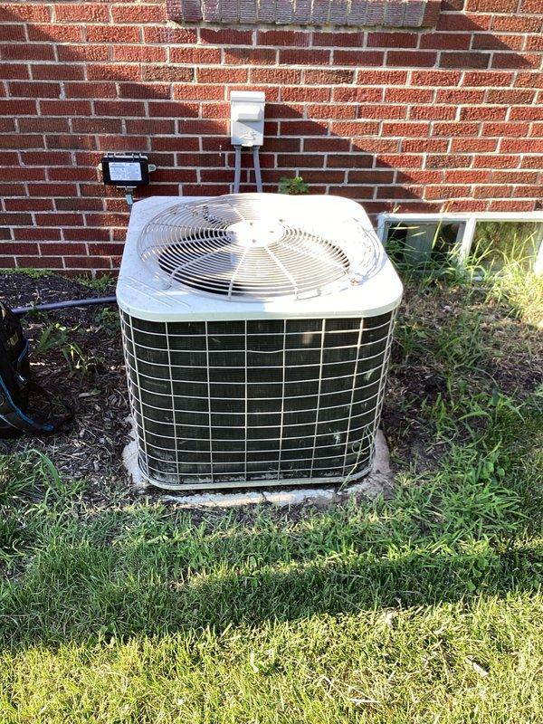Completed monthly basic cooling maintenance visit on residential air conditioning system. Performed standard inspection of outdoor condenser unit positioned against building exterior, verified proper operation of fan assembly and protective grille integrity, and confirmed adequate airflow through mesh panels. Checked thermostat functionality showing system maintaining 74°F setpoint with proper display operation and scheduling features active until 4:30PM. Replaced 16x20x1 air filter as included in basic monthly service agreement. All components operating within normal parameters with no immediate service concerns identified.