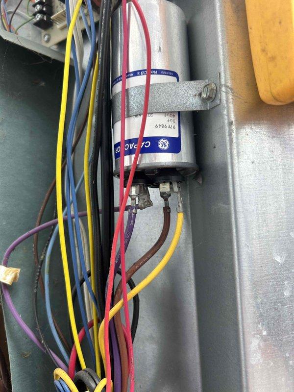 Responded to no cooling complaint on residential air conditioning system. Upon inspection, found failed dual-run capacitor preventing compressor and condenser fan operation. Replaced defective GE capacitor with new unit, verified proper microfarad ratings and voltage specifications, secured all electrical connections, and tested system operation. Unit restored to normal cooling operation with compressor and condenser fan running properly.