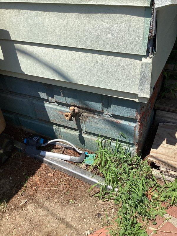 Responded to service callback for malfunctioning exterior hose bib that would not turn. Upon arrival, found severely corroded brass valve assembly mounted on exterior wall with significant rust staining and deterioration around pipe penetration point. Valve mechanism was seized due to age and weather exposure, preventing operation. Replaced failed hose bib with new frost-proof sillcock assembly, ensuring proper mounting and seal at wall penetration to prevent future water intrusion and rust damage. Tested new fixture for proper operation and verified no leaks at connection points.