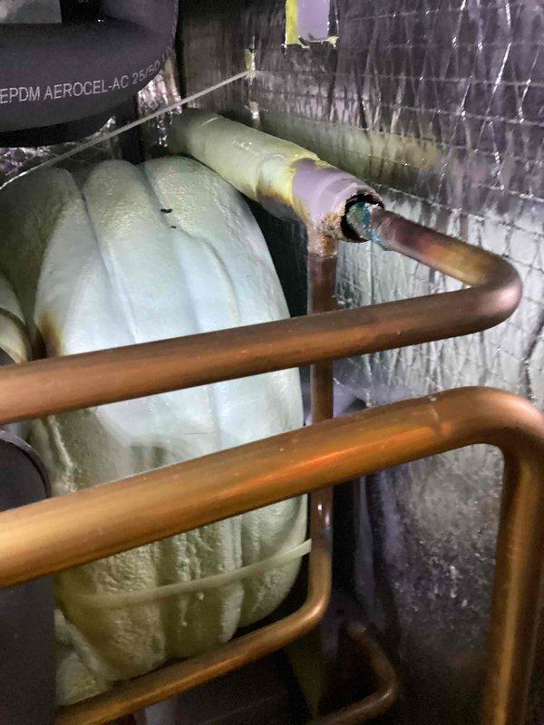 Responded to callback for E4 freeze detection error on WaterFurnace geothermal heat pump system. Upon arrival, inspected thermostat display confirming FP2 freeze protection trip alarm. Performed visual inspection of indoor unit, ductwork, and refrigerant lines in mechanical space. Reset freeze protection alarm and documented equipment condition with photos showing insulated supply ductwork, copper refrigerant piping, and geothermal unit installation. System operational at time of departure with customer advised to monitor for recurring alarms.