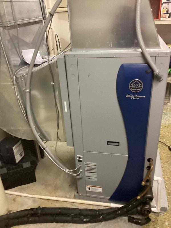 Responded to callback for E4 freeze detection error on WaterFurnace geothermal heat pump system. Upon arrival, inspected thermostat display confirming FP2 freeze protection trip alarm. Performed visual inspection of indoor unit, ductwork, and refrigerant lines in mechanical space. Reset freeze protection alarm and documented equipment condition with photos showing insulated supply ductwork, copper refrigerant piping, and geothermal unit installation. System operational at time of departure with customer advised to monitor for recurring alarms.