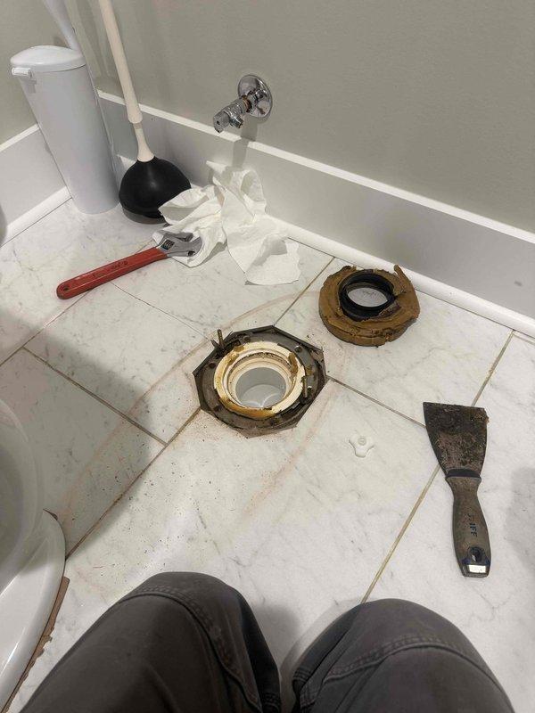 Responded to service call for toilet wax ring failure. Upon inspection, found severely corroded and deteriorated toilet flange rings requiring immediate replacement. Removed toilet from floor, extracted failed wax ring and damaged flange components. Installed new wax ring and reconnected toilet to water supply line, ensuring proper seal and stable mounting. Verified flush operation and checked for leaks at base and supply connection.