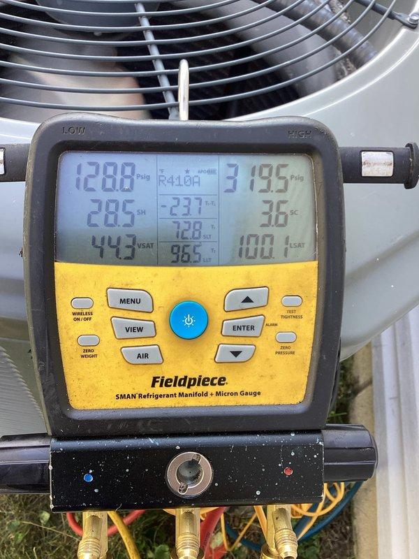 Responded to callback for system struggling to maintain setpoint temperatures throughout the day. Performed diagnostic evaluation of R410A system using refrigerant manifold and micron gauge at outdoor condenser unit. Measured operating pressures at 128.8 PSIG low side and 313.5 PSIG high side, with superheat reading of 44.3°F and subcooling at 10.1°F. Verified thermostat operation showing current temperature of 68°F with cooling setpoint at 72°F. System parameters indicate inadequate cooling capacity during peak load conditions requiring further evaluation of refrigerant charge and airflow.
