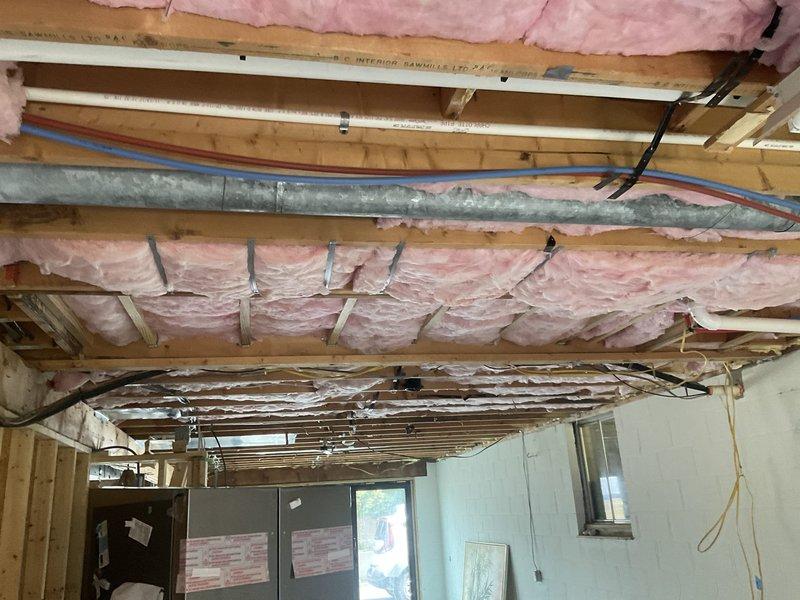 Provided estimate for relocating existing refrigerant line set from exterior AC condensing unit to indoor evaporator coil as part of customer's home renovation project. Assessed current line set configuration running along exterior wall and evaluated routing options through unfinished ceiling space with exposed joists, insulation, and existing HVAC ductwork to determine optimal path and material requirements for relocation.