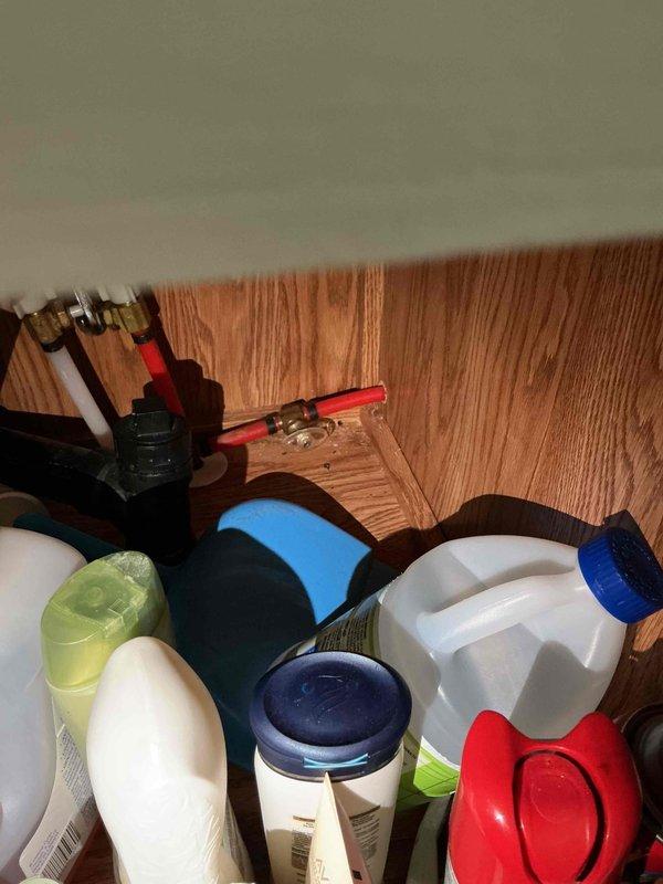 Responded to kitchen water leak investigation. Upon arrival, identified moisture damage on flooring near baseboard in corner area. Inspected potential sources including dishwasher and refrigerator water supply lines. Cleared items from affected area to access plumbing connections behind cabinetry. Examined supply lines, shut-off valves, and compression fittings for signs of active leaking or water intrusion. Customer advised to monitor area and provided recommendations for next steps pending source identification.