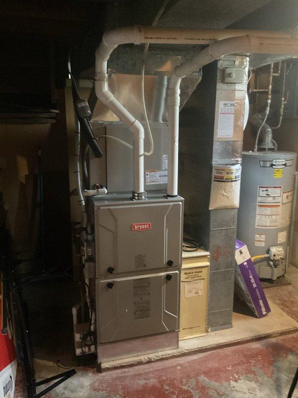 Conducted comprehensive evaluation of residential HVAC system with failed compressor in outdoor condenser unit. Assessed both exterior air conditioning equipment and interior Bryant furnace system in basement mechanical room to provide complete replacement estimate. Documented existing equipment condition, noting weathered outdoor unit with vegetation encroachment and complete system specifications for replacement recommendations, as homeowners were prepared to proceed with full system replacement rather than compressor repair.