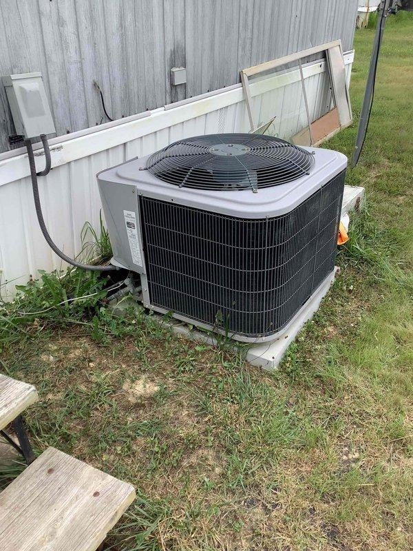 Responded to service call for residential AC unit experiencing intermittent operation and sparking issues. Upon arrival, performed diagnostic evaluation of outdoor condensing unit and electrical components. System exhibited failure to maintain continuous operation, with unit starting but shutting down shortly after. Inspected electrical connections at disconnect box and conduit runs, checking for loose wiring or damaged components that could cause arcing. Evaluated compressor operation and electrical draw to determine potential compressor failure as reported concern. Documented unit condition and installation location adjacent to metal structure with photographic evidence for service records.