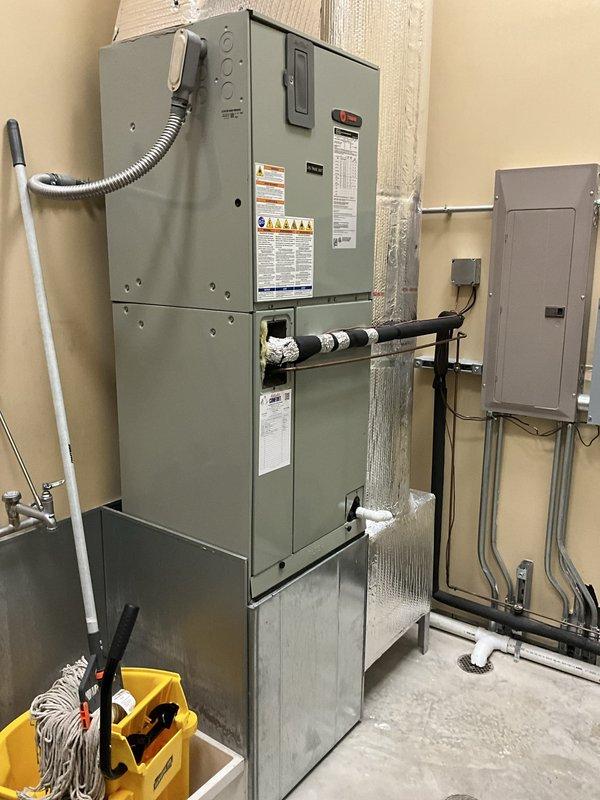 Conducted comprehensive assessment of two existing Trane HVAC systems for replacement evaluation. Inspected both air handler units, documented current equipment configurations, refrigerant line conditions, electrical connections, and ductwork installations. Photographed existing gray multi-tiered air handler with metallic ductwork, insulated refrigerant lines, and associated electrical panels to provide detailed documentation for replacement proposals. Evaluated second air handler unit with vertical insulated piping and noted proximity to water heater for clearance considerations during future equipment replacement. Assessed electrical service capacity, conduit routing, and mounting configurations to ensure proper planning for new equipment installations.