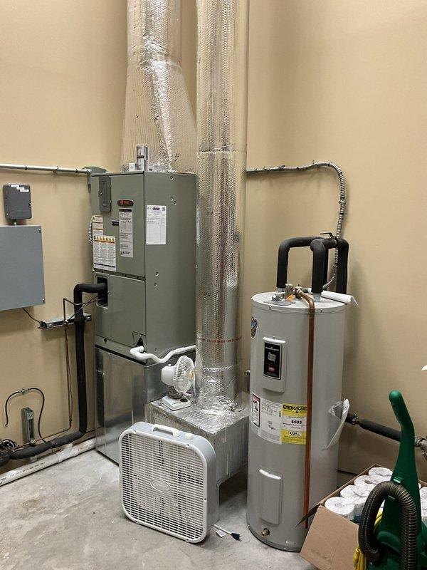 Conducted comprehensive assessment of two existing Trane HVAC systems for replacement evaluation. Inspected both air handler units, documented current equipment configurations, refrigerant line conditions, electrical connections, and ductwork installations. Photographed existing gray multi-tiered air handler with metallic ductwork, insulated refrigerant lines, and associated electrical panels to provide detailed documentation for replacement proposals. Evaluated second air handler unit with vertical insulated piping and noted proximity to water heater for clearance considerations during future equipment replacement. Assessed electrical service capacity, conduit routing, and mounting configurations to ensure proper planning for new equipment installations.