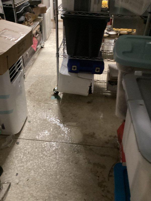 Responded to water leak call originating from HVAC unit located in garage area. Upon arrival, customer was not present as previously communicated. Conducted thorough inspection of the affected area, which included basement storage space with extensive water accumulation on concrete flooring. Documented moisture damage with photographic evidence showing standing water, wet patches, and reflective puddles throughout the corridor and storage areas. Identified water staining patterns on concrete surface indicating active leak from overhead unit. Inspected wire shelving units, stored items, and dehumidifier equipment in vicinity of leak source to assess extent of water intrusion and potential secondary damage to customer property.