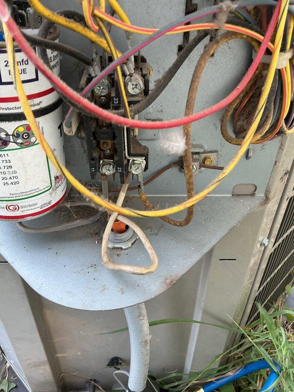 Performed comprehensive AC tune-up on aging outdoor condensing unit during morning service window. Completed full system inspection including electrical components, capacitor, contactor assembly, and all wire connections. Unit showed significant weathering and rust staining on housing consistent with extended outdoor exposure, but all components were functioning within normal parameters at time of service. Documented system condition with photos showing interior electrical components and exterior cabinet. System operating properly with no immediate repairs required.