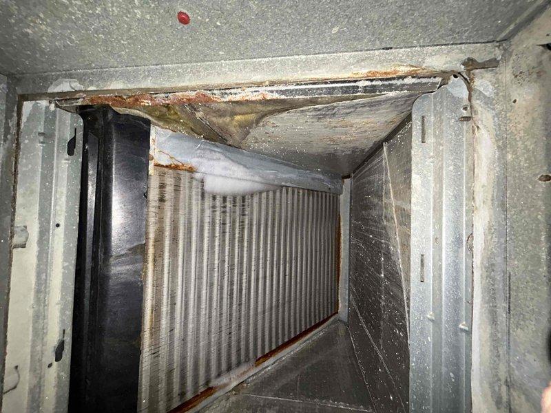 Responded to no cooling complaint on one of two residential air conditioning units. Upon inspection, found electrical connections requiring attention and observed significant rust and corrosion on interior metal surfaces of air handler, along with dirty evaporator coil and accumulated debris within ductwork. Documented system condition with photos showing deteriorated components, moisture damage, and maintenance needs for future reference.