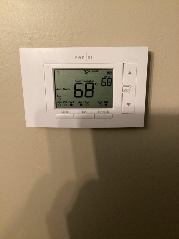 Completed basic monthly cooling maintenance visit on residential HVAC system. Verified thermostat operation showing system in auto mode at 68°F with 88% humidity reading, confirmed wireless connectivity and proper display function. Inspected air filter measuring 16x20x1 with purple border currently installed in unit, noted filter dimensions do not match standard 20x20x4 specification for this system, and documented existing service records and accessory kit information posted inside unit compartment.