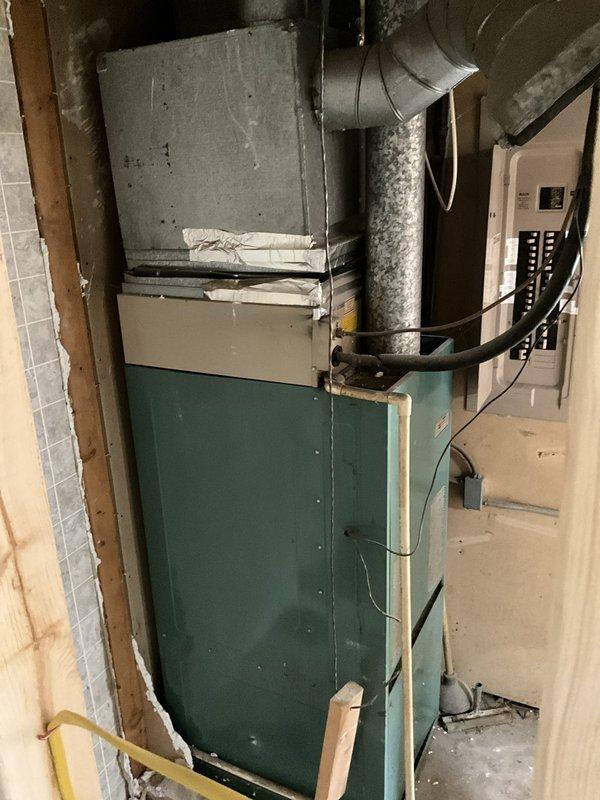Conducted comprehensive site evaluation for commercial HVAC system replacement in utility room with existing aging furnace unit showing signs of wear and water damage to surrounding infrastructure. Documented current equipment configuration including ductwork layout, electrical panel connections, and spatial constraints for new installation planning. Provided detailed photographic documentation and prepared full system replacement estimate for customer review.