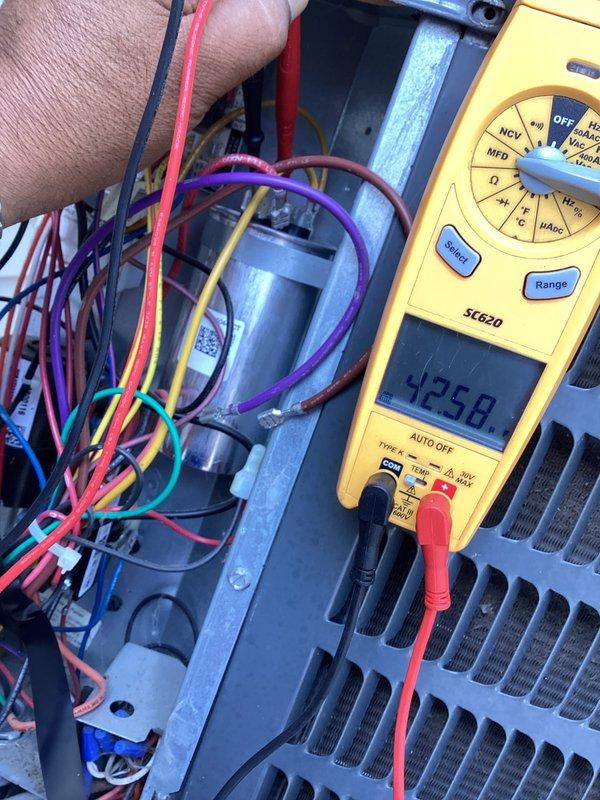 # HVAC Maintenance - Cooling System Service

Completed basic monthly cooling maintenance visit on Goodman residential air conditioning system. Performed electrical diagnostics using digital multimeter, recording voltage reading of 4258 on system components. Tested electrical connections and capacitor performance within the condenser unit's control panel, verifying proper operation of all wiring connections including power and control circuits.

Inspected outdoor condenser unit positioned on concrete pad. Verified proper airflow through horizontal fin assembly and protective grille. Confirmed unit operational status with no visible damage or deterioration to external components. All electrical conduit and refrigerant line protection verified secure along exterior mounting.

System operating within normal parameters. No immediate repairs required at this time.