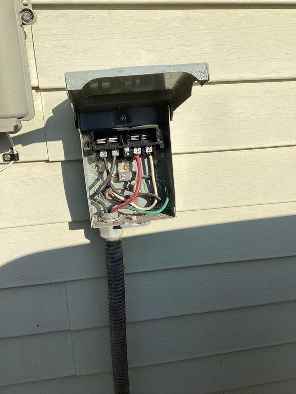 Responded to grounding concern at exterior electrical disconnect panel. Upon inspection, found improper grounding configuration requiring documentation and correction. Verified voltage readings at 218V AC using calibrated clamp meter to ensure system was operating within acceptable parameters. Photographed existing conditions showing multiple circuit breakers, conductor routing, and grounding connections for record and further evaluation. Documented flexible metal conduit installation and overall panel configuration to address the grounding anomaly identified during initial assessment.