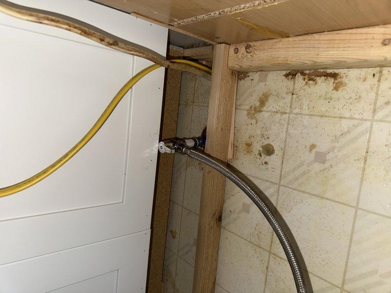 Relocated dishwasher shut-off valve approximately one foot to accommodate new appliance installation. Accessed existing plumbing through cabinet cavity, extended supply line using braided stainless steel connector, and secured new valve position to meet clearance requirements for replacement dishwasher unit.