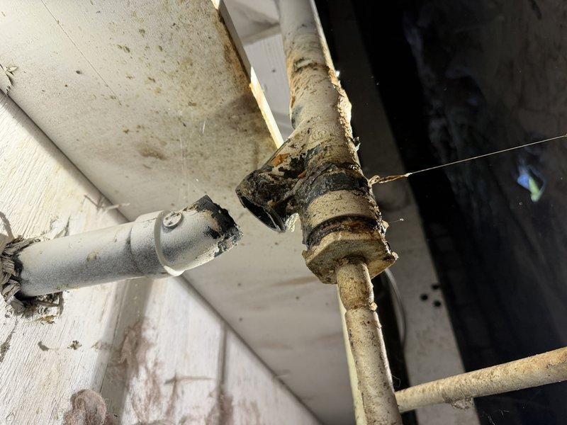 Responded to service call for low water pressure at kitchen faucet. Inspected crawlspace plumbing and identified severely corroded and deteriorated supply piping with significant rust buildup and mineral deposits affecting water flow. Documented existing conditions showing compromised pipe integrity at connection points and recommended replacement of affected sections to restore proper water pressure and prevent potential leaks.