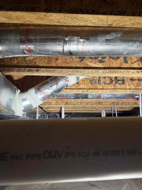 Completed HVAC system installation by connecting fresh air intake ductwork to the main system through attic and crawl space areas. Installed dampers in all supply lines to ensure proper airflow distribution and zone control throughout the structure, with all ductwork properly secured to floor joists using metal hangers and brackets.
