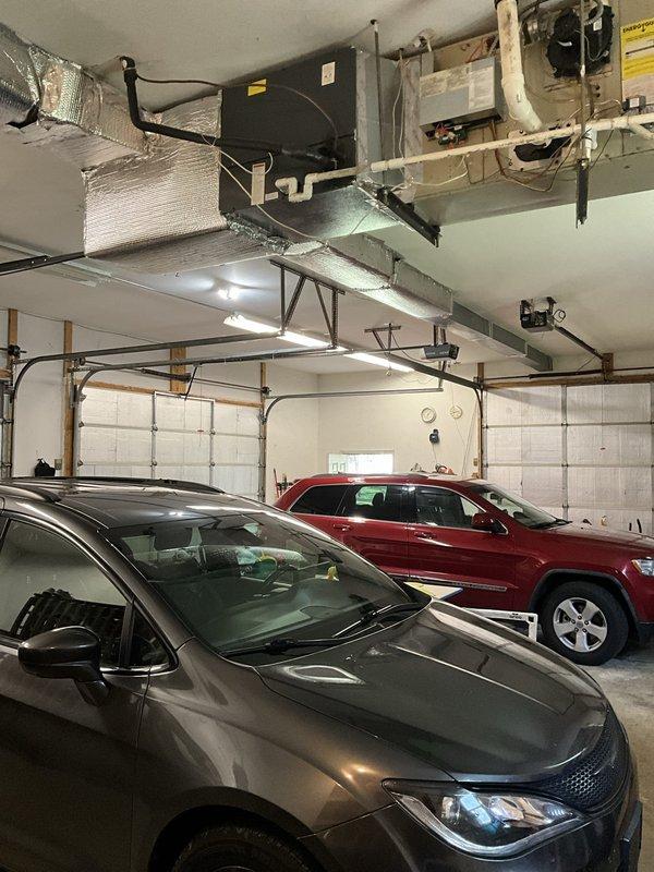 Responded to service call for 18-year-old ceiling-mounted HVAC unit in garage experiencing recurring refrigerant loss. Conducted assessment of system mounted at 14-foot ceiling height and documented existing equipment configuration including air handler, ductwork, and associated components. Provided replacement estimate for aging unit due to repeated refrigerant charging requirements indicating potential system failure.