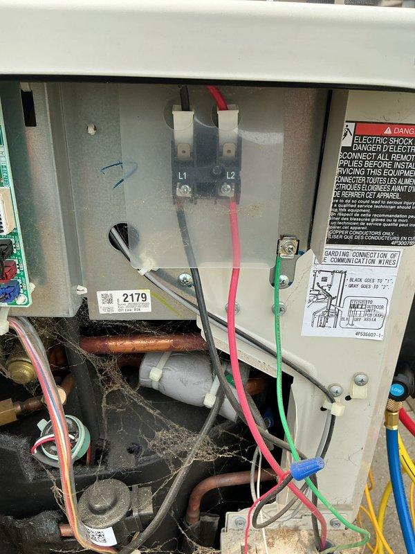 Completed routine maintenance on 4-year-old heating and cooling system per customer request. Performed comprehensive AC tune-up including inspection of electrical connections at L1 and L2 terminals, verified proper wire terminations and grounding connections, and examined control panel wiring and components. Inspected capacitor, refrigerant lines, and internal components for proper operation. Cleaned accumulated dust and debris from electrical compartment and verified all safety labels and warnings were intact and legible. Confirmed all electrical connections were secure with no signs of overheating or corrosion. System tested and operating within normal parameters with no issues identified.