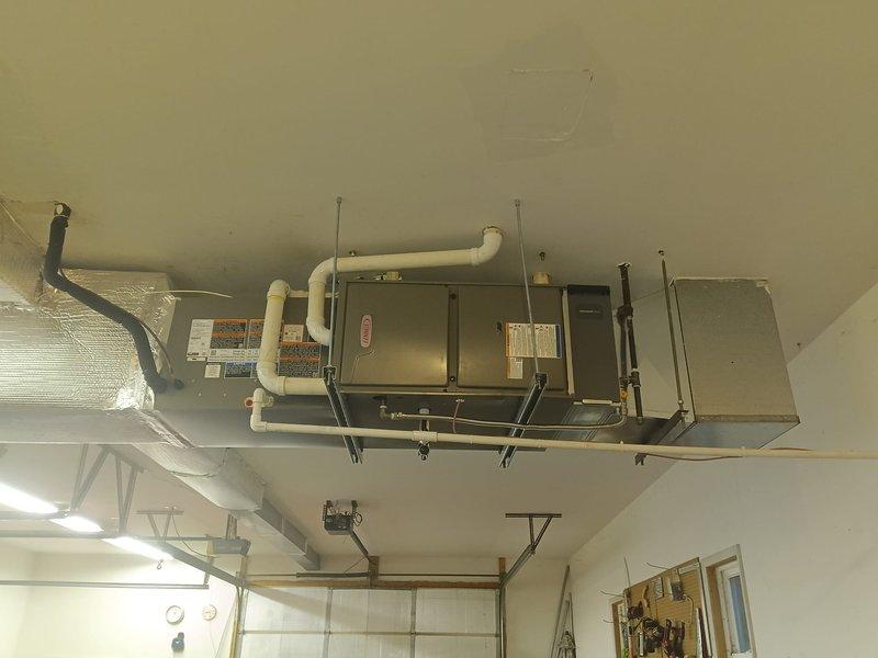Completed full HVAC system installation consisting of Lennox air conditioning unit and gas furnace in garage location. Installed ceiling-mounted air handler with proper metal brackets and suspension straps, routed PVC condensate drainage lines with appropriate pitch and bends, and connected insulated flexible ductwork with reflective covering. Mounted electrical junction box and completed all necessary electrical connections to code. Verified system operation with temperature readings confirming proper furnace ignition and heat output at 232°F. All components labeled per manufacturer specifications, condensate lines properly secured, and system tested for full functionality.