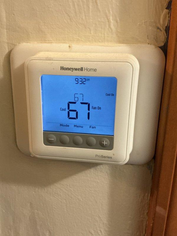 Completed Comfort Care maintenance on residential cooling system. Inspected air filter assembly and found filter in clean condition with proper installation in basement air handler unit. Verified thermostat operation with Honeywell ProSeries digital control displaying proper cooling mode activation, fan operation, and system response at 9:32 AM reading. All components functioning within normal parameters.