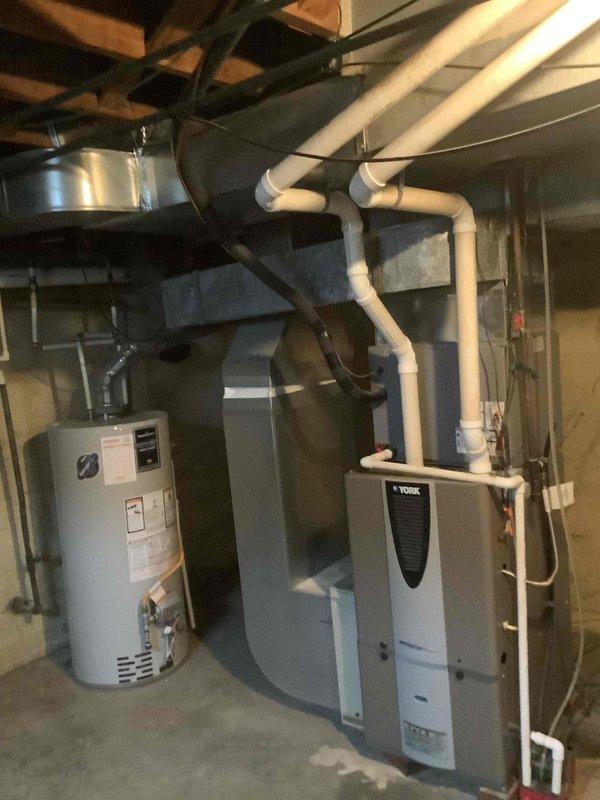 Performed comprehensive site assessment of residential HVAC ductwork system in basement mechanical room for new homeowner requesting duct cleaning estimate. Inspected York furnace/air handler unit, associated supply and return ductwork, and PVC condensate drainage system to evaluate accessibility and condition of duct system. Documented interior duct conditions showing accumulated debris and particulate matter on concrete surfaces beneath system, confirming need for professional duct cleaning services to improve indoor air quality and system efficiency.