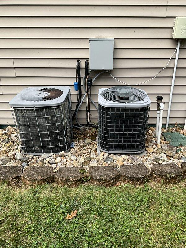 Conducted comfort consultation and system evaluation for downstairs cooling unit replacement. Assessed aging Heil system and documented existing dual outdoor condensing unit configuration with electrical disconnects and indoor air handler unit manufactured in February 2015 (Model END4X30L17A1, R-410A refrigerant). Provided replacement options based on system age and anticipated repair costs, captured photographic documentation of current installation for proposal development.