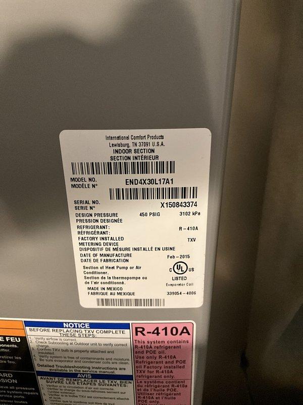 Conducted comfort consultation and system evaluation for downstairs cooling unit replacement. Assessed aging Heil system and documented existing dual outdoor condensing unit configuration with electrical disconnects and indoor air handler unit manufactured in February 2015 (Model END4X30L17A1, R-410A refrigerant). Provided replacement options based on system age and anticipated repair costs, captured photographic documentation of current installation for proposal development.