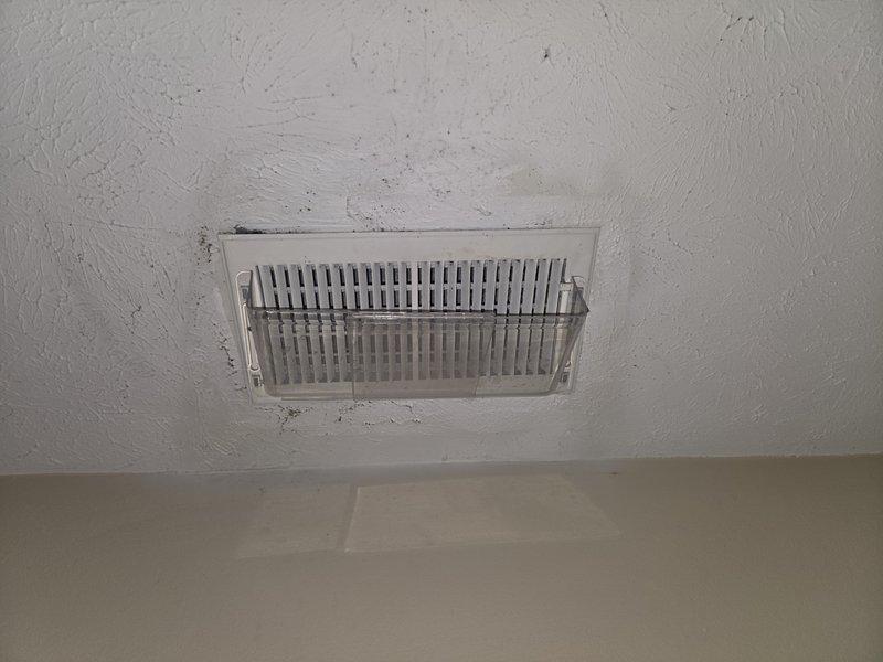 Responded to indoor air quality concern regarding reported mold growth in ductwork system. Upon arrival, performed visual inspection of accessible supply registers and documented conditions with photographs. Inspection revealed significant dust accumulation and dark staining patterns around multiple ceiling-mounted supply vents, with discoloration extending outward from register perimeters indicating potential moisture intrusion or microbial growth. Noted visible streaking and contamination on vent covers and surrounding ceiling surfaces. Documented current conditions for customer review and further remediation planning.