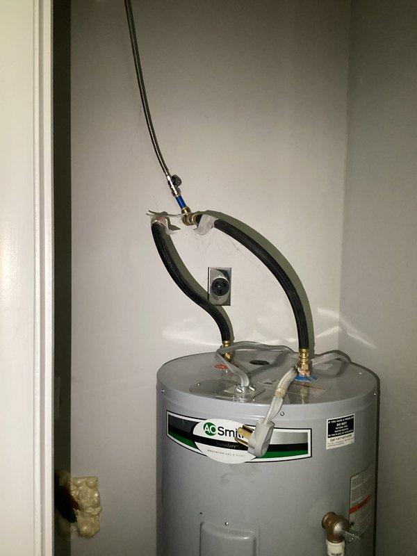 Responded to service call for intermittent hot water loss occurring approximately three times weekly on A.O. Smith tanked water heater unit. Upon arrival, conducted visual inspection of water heater installation in utility closet. Examined all visible components including water inlet/outlet connections with black flexible hoses and brass fittings, copper piping, electrical control box, and brass drain valve. Verified proper installation configuration and documented unit condition through photographic evidence. All connections, fittings, and mounting appeared secure with no visible signs of leaking or corrosion at time of inspection.