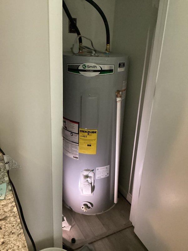 Responded to service call for intermittent hot water loss occurring approximately three times weekly on A.O. Smith tanked water heater unit. Upon arrival, conducted visual inspection of water heater installation in utility closet. Examined all visible components including water inlet/outlet connections with black flexible hoses and brass fittings, copper piping, electrical control box, and brass drain valve. Verified proper installation configuration and documented unit condition through photographic evidence. All connections, fittings, and mounting appeared secure with no visible signs of leaking or corrosion at time of inspection.