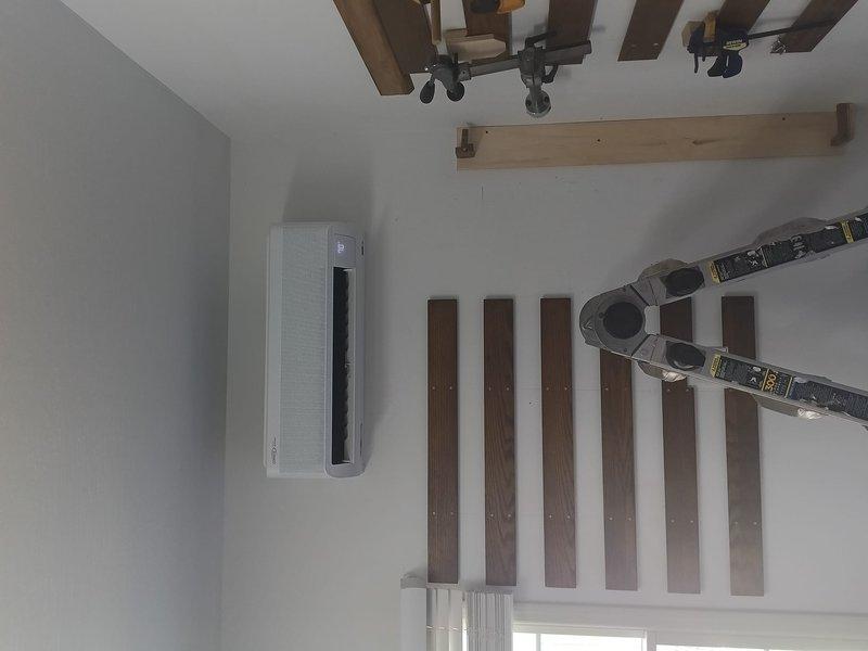 Completed installation of ductless mini-split air conditioning system in residential space with exposed beam ceiling. Mounted indoor wall unit on interior wall, routed refrigerant lines and electrical connections, and verified system operation and proper airflow upon startup.