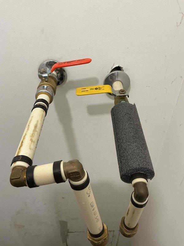 Responded to water leak investigation for unit experiencing moisture intrusion of unknown origin. Upon arrival, observed active water damage on interior ceiling with visible staining and discoloration indicating ongoing moisture penetration. Installed collection tray beneath compromised ceiling area and accessed ceiling cavity through existing panel to inspect for source. Inspected visible plumbing infrastructure including PVC supply lines, ball valve, and pressure regulator assembly with insulated piping sections. Unable to locate definitive leak source within the unit's accessible plumbing system or ceiling cavity. Documented conditions with photographs showing ceiling damage pattern and plumbing configuration. Leak may be originating from adjacent unit or building infrastructure requiring further investigation beyond scope of current access points.