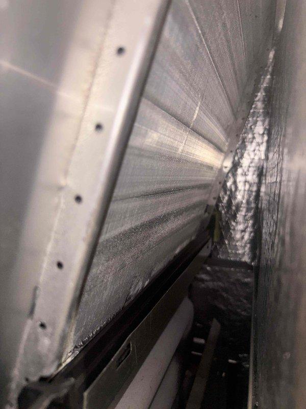 # HVAC Maintenance Report

Completed monthly basic cooling system maintenance visit. Upon inspection, discovered significant frost and ice accumulation on the evaporator coil assembly, indicating potential airflow restriction or refrigerant issues. Documented system temperature reading of 71.6°F at the ductwork. The ice buildup was isolated to one side of the coil fins, while the opposite side remained clear, suggesting uneven airflow distribution or possible low refrigerant charge. Photographed conditions for service records and further diagnostic evaluation may be required to address the underlying cause of coil icing.