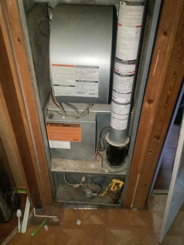 Responded to no cooling complaint on residential air conditioning system. Performed comprehensive system inspection and diagnostic evaluation of vertically-stacked HVAC unit installed in utility closet. Conducted visual assessment of all accessible components including air handler, evaporator coil assembly, condensate drainage, refrigerant line connections, and ductwork. Documented equipment model and serial numbers for service records. Evaluated system operation, airflow, and temperature differentials across the evaporator coil. Inspected electrical connections, safety controls, and caution labels for proper operation. Assessed flexible ductwork condition and sealing integrity. System photographed for documentation purposes showing complete installation configuration and equipment identification labels.
