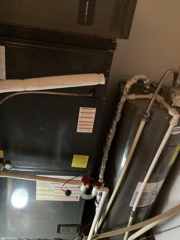 Responded to no cooling call at commercial facility. Upon arrival, inspected HVAC system including condenser unit located on building exterior and air handler/water heater equipment in mechanical room. Found condenser unit obstructed by overgrown vegetation restricting airflow to unit. Cleared vegetation and debris from around condenser to restore proper airflow and system operation. Verified system cooling function restored and unit operating within normal parameters.