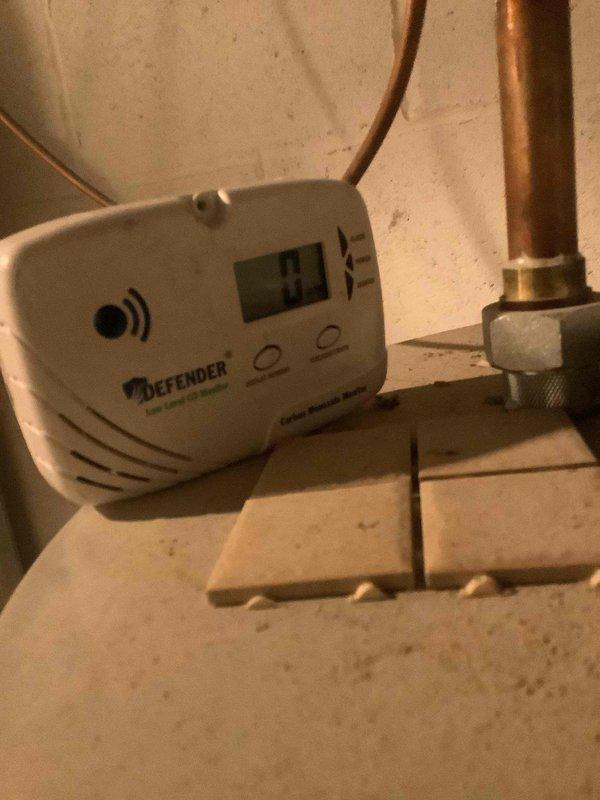 Responded to service call for combustion safety analysis. Upon arrival, discovered combustion analyzer was non-functional and unable to complete required testing. Inspected DEFENDER low-level carbon monoxide monitor in mechanical area, which displayed a reading of 93 PPM. Documented existing conditions with photos showing CO monitor placement near gas piping and copper plumbing infrastructure in utility space. Scheduled return visit with operational combustion analyzer to complete comprehensive combustion safety testing and system diagnostics.