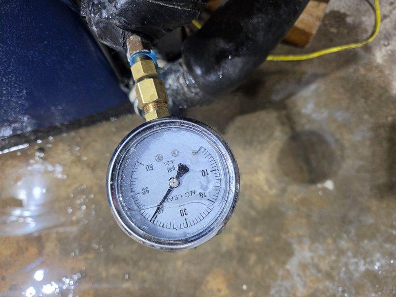 Installed loop conditioner with T-fitting and pressure gauge to allow for system monitoring and diagnostics. Added brass T-connector to refrigerant line with gauge port, enabling technician access for pressure readings and system performance checks. Completed installation with all connections properly secured and gauge operational for future service needs.