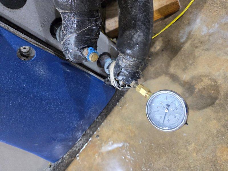 Installed loop conditioner with T-fitting and pressure gauge to allow for system monitoring and diagnostics. Added brass T-connector to refrigerant line with gauge port, enabling technician access for pressure readings and system performance checks. Completed installation with all connections properly secured and gauge operational for future service needs.