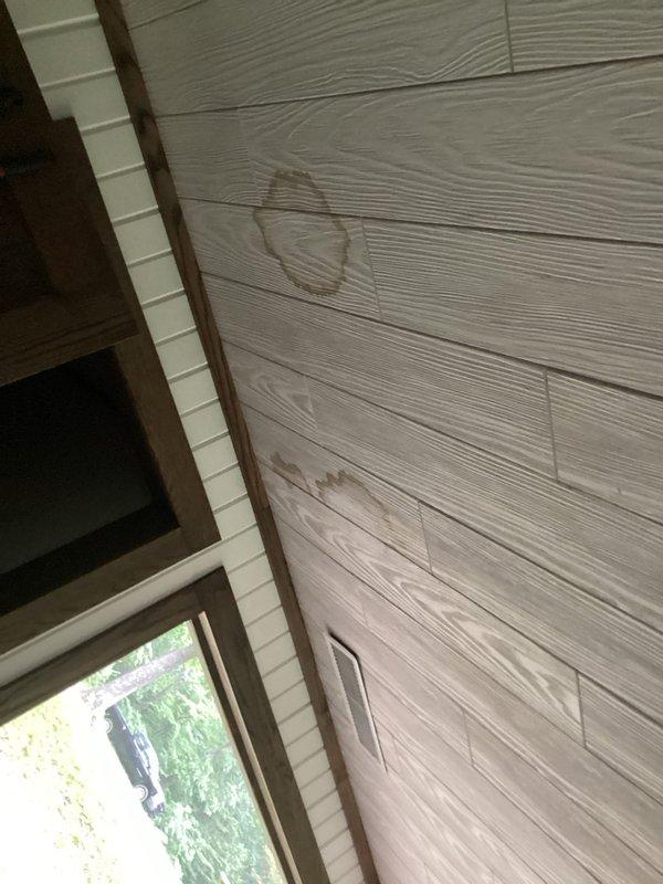 Responded to service call for water damage caused by excessive condensation from HVAC vent system. Upon inspection, identified significant condensation accumulation at attic ductwork penetration point, resulting in moisture intrusion and visible ceiling staining in living space. Documented existing water damage to interior wall paneling and assessed attic ductwork configuration, including reflective insulation and vent connections, to determine source of condensation issue and recommend appropriate corrective measures.