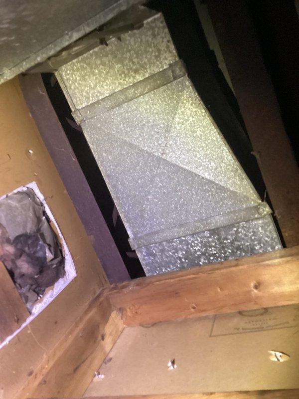 Responded to service call for water damage caused by excessive condensation from HVAC vent system. Upon inspection, identified significant condensation accumulation at attic ductwork penetration point, resulting in moisture intrusion and visible ceiling staining in living space. Documented existing water damage to interior wall paneling and assessed attic ductwork configuration, including reflective insulation and vent connections, to determine source of condensation issue and recommend appropriate corrective measures.