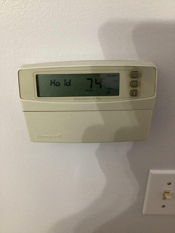 # HVAC Cooling System Repair

Responded to service call for 11-year-old air conditioning system experiencing insufficient cooling and ice buildup on evaporator coil. Upon arrival, confirmed unit was unable to maintain proper temperature and observed frost accumulation indicating restricted airflow or refrigerant issues.

Performed comprehensive system diagnostics including inspection of indoor air handler components, ductwork connections, and thermostat operation. Examined Honeywell Chronotherm IV Plus programmable thermostat which was displaying hold mode at 74 degrees. Accessed air handler cabinet and inspected evaporator coil assembly, blower motor, and associated ductwork framing. Checked for common causes of icing including dirty air filters, blocked return air pathways, low refrigerant charge, and restricted airflow through the evaporator coil.

Identified primary issue causing inadequate cooling performance and ice formation. Cleared obstruction and restored proper system airflo