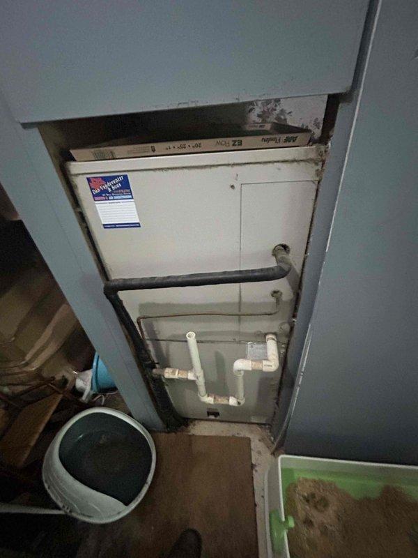 Responded to no cooling complaint affecting entire residence. Upon arrival, performed comprehensive system diagnostics on split air conditioning system. Inspected indoor air handler unit located in utility closet, noting age-related wear and environmental conditions including ceiling water damage and deterioration in mechanical room. Examined outdoor condensing unit and electrical connections, documenting wiring configuration with multiple circuits converging at capacitor terminals. Verified proper wire connections using appropriately rated wire nuts for all power and control circuits. Evaluated refrigerant charge levels and system pressures to determine root cause of cooling loss following recent service by another provider. Documented equipment condition through photographic evidence showing internal electrical components and air handler installation. System assessed for potential refrigerant leak, electrical faults, and airflow restrictions.