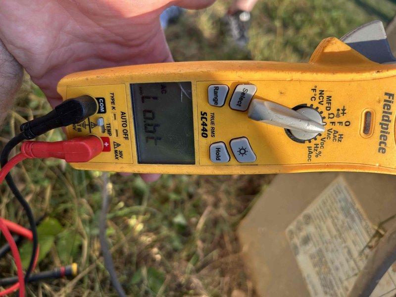 Responded to no cooling complaint on residential outdoor condensing unit aged 10+ years. Upon arrival, performed electrical diagnostics using clamp meter which indicated no power draw to compressor. Inspected condenser unit exterior condition, noting weathered cabinet and mesh grilles consistent with age, and verified unit positioning on concrete pad with adequate clearance. Recommended further evaluation of compressor contactor, capacitor, and electrical supply to determine root cause of system failure.