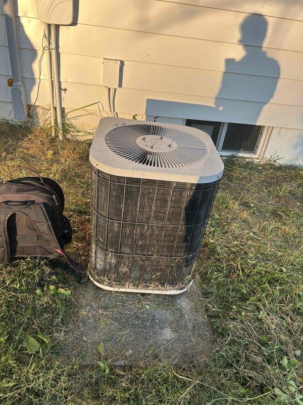 Responded to no cooling complaint on residential outdoor condensing unit aged 10+ years. Upon arrival, performed electrical diagnostics using clamp meter which indicated no power draw to compressor. Inspected condenser unit exterior condition, noting weathered cabinet and mesh grilles consistent with age, and verified unit positioning on concrete pad with adequate clearance. Recommended further evaluation of compressor contactor, capacitor, and electrical supply to determine root cause of system failure.